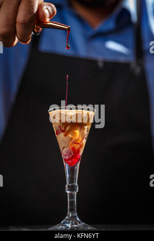 The Bartender makes Brain cocktail in a shot glass Stock Photo