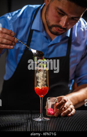 Bartender preparing a champagne cocktail with rose jam Stock Photo