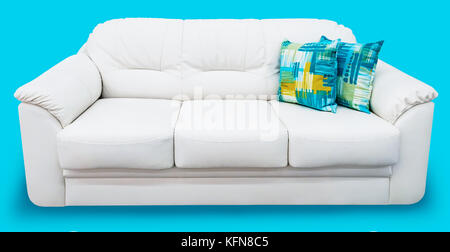 White eco leather sofa with blue pillow. Soft snow white couch with coach-type screed capitone. Classic divan on isolated background Stock Photo