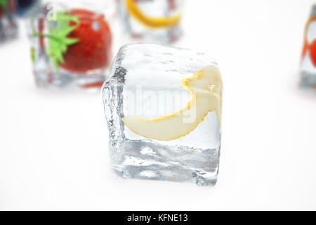 Melon in ice cube isolated on white with depth of field effects. Ice cubes with fresh berries. Berries fruits frozen in ice cubes, 3D rendering Stock Photo