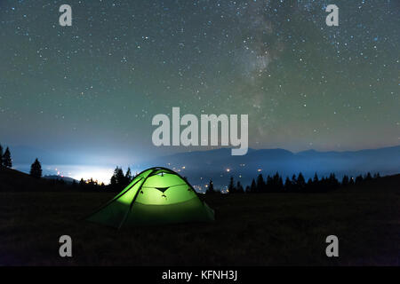 Green tent lighted from the inside Stock Photo