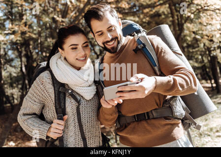 Waist up of positive couple using mobile phone Stock Photo