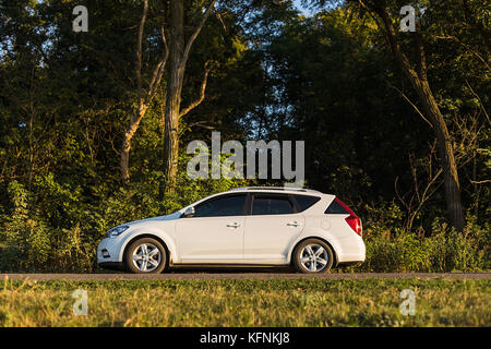 DNIPROPETROVSK REGION, UKRAINE - MARCH 25, 2015: KIA CEED ON THE ROAD NEAR THE FOREST Stock Photo