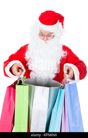 Surprised santa looking inside shopping bag on white background Stock Photo
