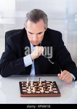 Portrait of a mature businessman playing chess Stock Photo