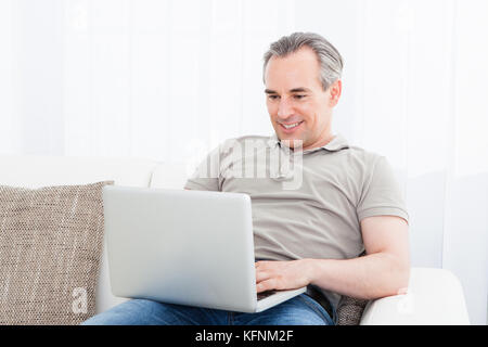 Portrait of a happy mature man using laptop Stock Photo