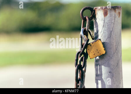 Steel chain on a pole with open lock Stock Photo
