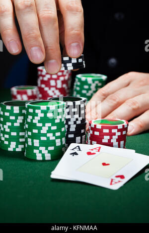 Portrait of a happy croupier holding gambling chips on table Stock Photo