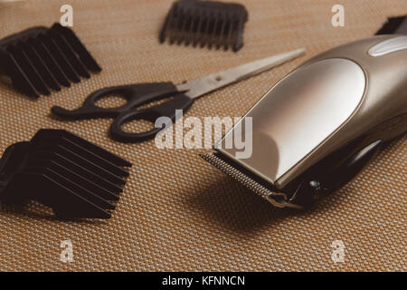 Stylish Professional Hair Clippers, accessories on brown background Stock Photo