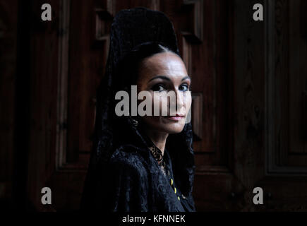 Group of Manolas go inside in the church during the procession of Holy Week Stock Photo