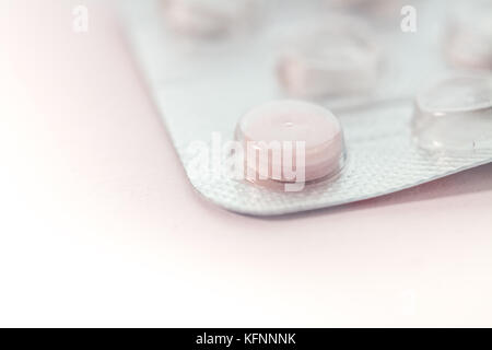 Macro of a single tablet in blister pack isolated on white backdrop Stock Photo