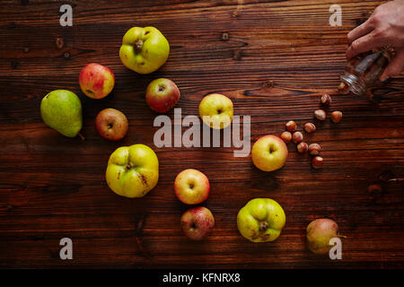 apple and quince hand pouring out nuts Stock Photo
