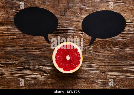 sliced organic grapefruit with two speech bubbles Stock Photo