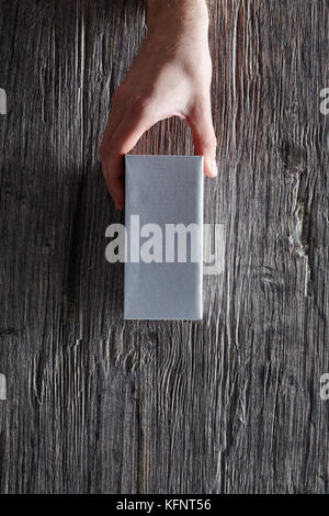 hand holding unbranded box from top mail transportation Stock Photo