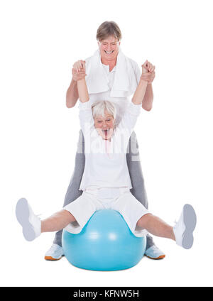 Happy Senior Couple Exercising With Fitness Ball On White Background Stock Photo