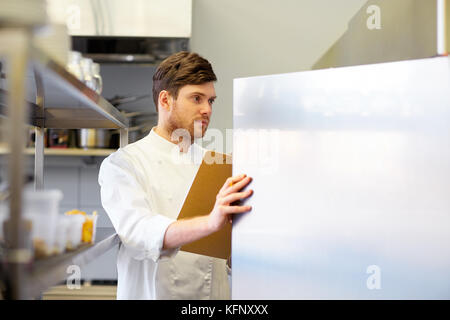 chef with clipboard doing inventory at kitchen Stock Photo