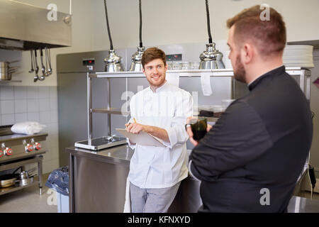 happy smiling chef and cook at restaurant kitchen Stock Photo