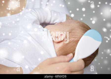 close up of mother brushing newborn baby hair Stock Photo