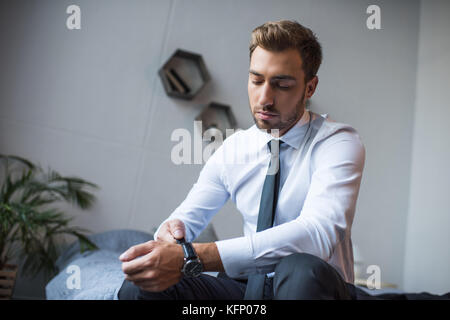 Businessman putting on watch Stock Photo - Alamy