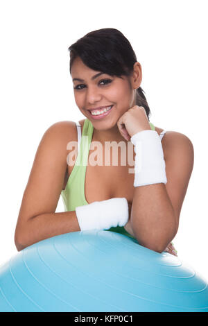Young Woman Leaning On Fitness Ball Over White Background Stock Photo
