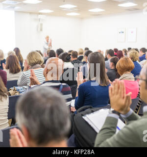 Woman giving interactive motivational speech at entrepreneurship workshop. Stock Photo