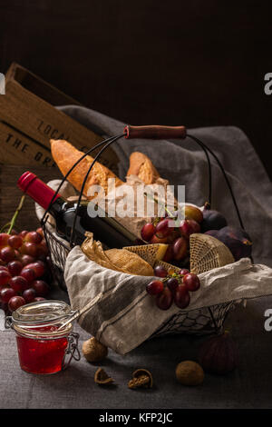 Picnic basket with cheese, fruits, bread and wine Stock Photo