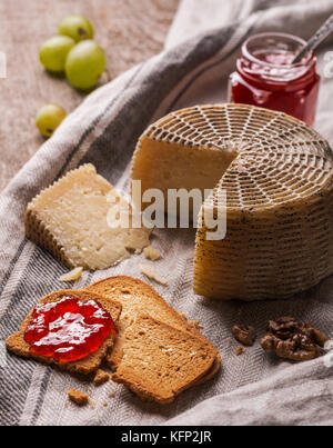 Still life with goat cheese, bread slices and jam Stock Photo