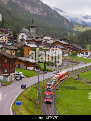 HERBRIGGEN, SWITZERLAND - Railroad train passes by village. Stock Photo