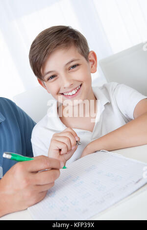 Portrait Of Son Doing Homework At Home Stock Photo