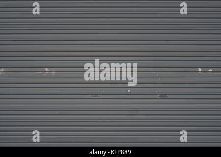 Gray metal roller shutter door or gate wall closed background and texture. vintage tone. Stock Photo