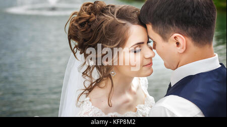 Attractive bride and groom near the lake