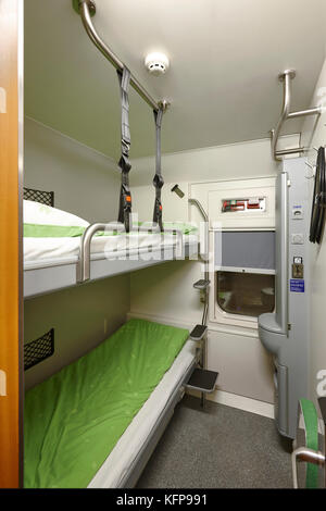 Train berth indoor with two beds. Travel background. Vertical Stock Photo