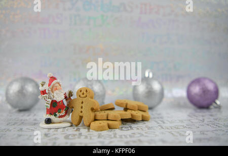 silver and lilac color Christmas food photography image with cute happy ginger bread man men with glitter xmas tree baubles and Santa Claus decoration Stock Photo