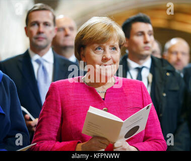 Wittenberg, Germany. 31st Oct, 2017. German Chancellor Angela Merkel (CDU, C) and government spokesman Steffen Ruediger (L) attend a church service marking the 500th anniversary of the beginning of the Reformation, at the Schlosskirche (Castle Church) in Wittenberg, Germany, 31 October 2017. Credit: dpa picture alliance/Alamy Live News Stock Photo