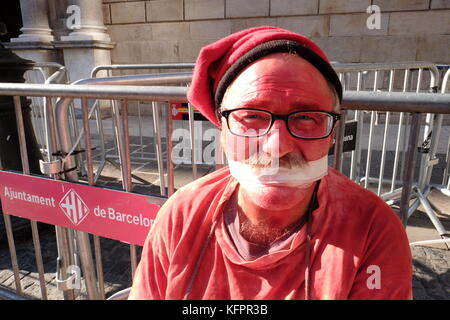 Barcelona, Spain. 31st Oct, 2017. A man wearing a 'Berretina' cap and tape across his mouth, sits outside the Generalitat de Catalunya (Headquarters of the Catalan Presidency). Credit: Joe O'Brien/Alamy Live News Stock Photo