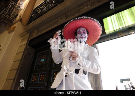 Barcelona, Spain. 31st Oct, 2017. A man wearing a Mexican style halloween costume and holding a toy skeleton. Joe O'Brien/Alamy Live News Stock Photo