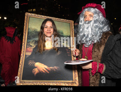 New York, USA. 31st Oct, 2017. Revelers wear costumes as Italian Renaissance painter Leonardo da Vinci and her Mona Lisa painting they march through New York's 6th Avenue during the Greenwich Village Halloween Parade. Credit: Enrique Shore/Alamy Live News Stock Photo