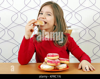 hungry little girl eat sweet donuts Stock Photo