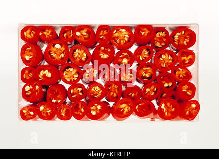Still life. Food. Close up of sliced red chilli peppers in ceramic dish. Stock Photo