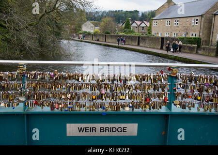 Love locks attached to Weir bridge, over the river Wye, Bakewell, Derbyshire, England, UK. Stock Photo