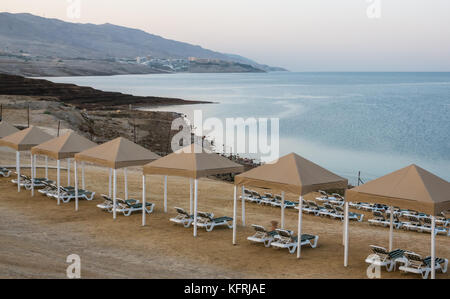 Early morning light at Holiday Inn Dead Sea resort, with empty beach sun loungers, Jordan, Middle East, and view over Dead Sea Stock Photo