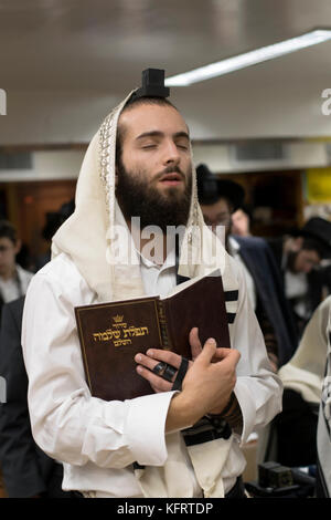 An orthodox Jewish man in thoughtful prayer at a synagogue in Crown Heights, Brooklyn, New York. Stock Photo