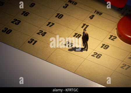 Miniature people Stand with light from the lamp on Calendar. Day 25 meets Christmas Day using as background business concept with copy space. Stock Photo