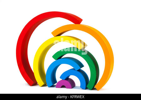 A wooden toy of seven different-colored arcs in the form of a rainbow on a white isolated background, the arcs are stacked on top of each other Stock Photo