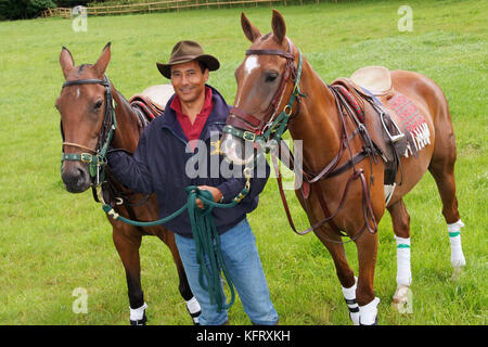 Martin Ephson with his polo ponies 'Vampiro' (white spot on head and red disc on bridle) and 'Jungle' at his home in Wiltshire. Stock Photo