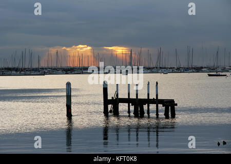 Sun breaking through the clouds over a marina in Port Phillip Bay, Melbourne, Australia Stock Photo
