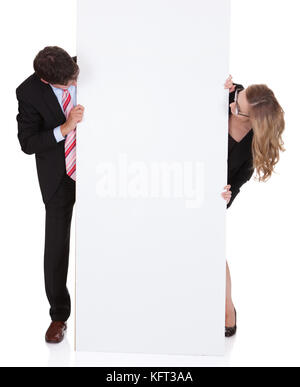 Smiling professional man and woman wearing glasses holding up a blank white sign for your text or advertisement isolated on white Stock Photo
