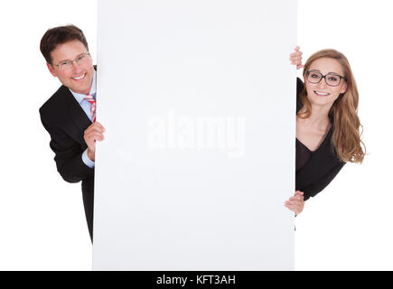 Smiling professional man and woman wearing glasses holding up a blank white sign for your text or advertisement isolated on white Stock Photo
