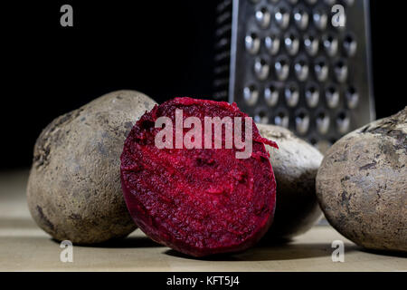 Beetroots grated on shavings. Wooden dining table. Black background. Stock Photo