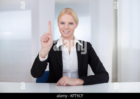 Beautiful businesswoman touching the screen with her finger Stock Photo